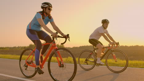 Two-cyclists-ride-together-in-mountains.-Softly-focused-hand-held-shot-of-two-professional-cyclists-from-sport-team-having-fun-during-hard-training-sprinting